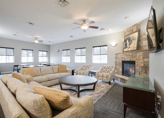 a clubhouse room with couches and a tv next to a fireplace