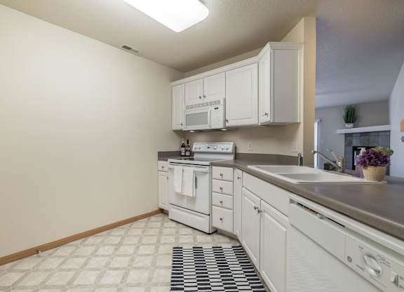 A kitchen with white cabinets and appliances.