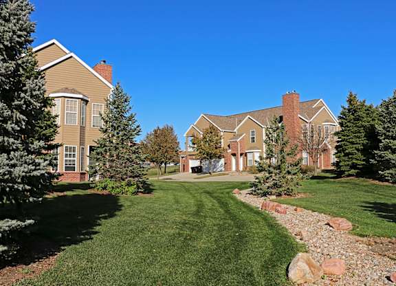Villas buildings with a well-manicured lawn and a clear blue sky.