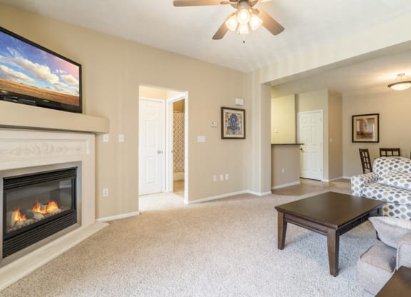 Interiors-Living room with fireplace and ceiling fan at Ridge Pointe Villas
