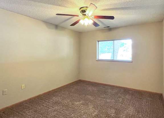 a bedroom with a ceiling fan and a window