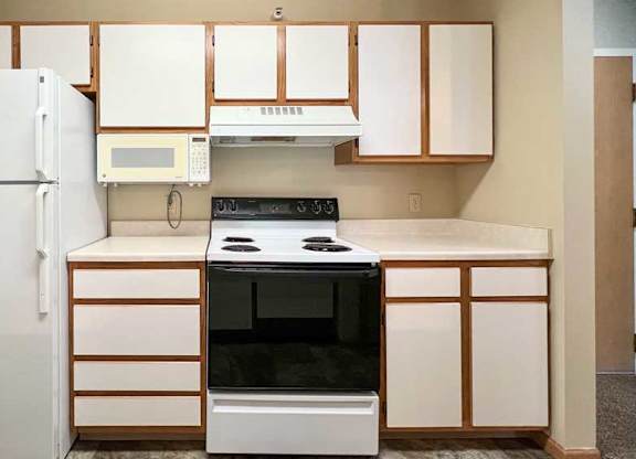 a kitchen with white white appliances and white and brown cabinets