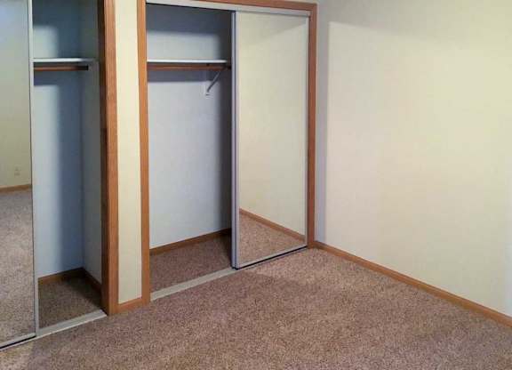 a bedroom with two closets with sliding mirror doors