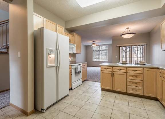 A kitchen with a refrigerator, oven, and cabinets.