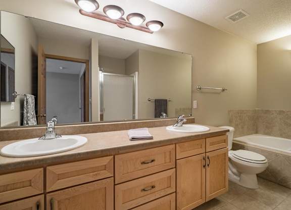 A bathroom with a sink, mirror, and toilet.