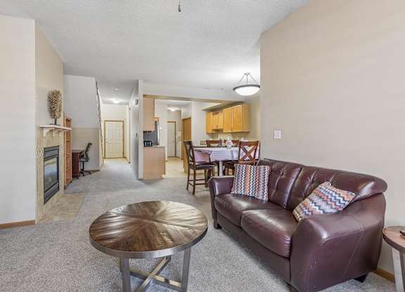Open apartment kitchen with light wood cabinets, tile flooring, ample counter space, and adjacent dining area.