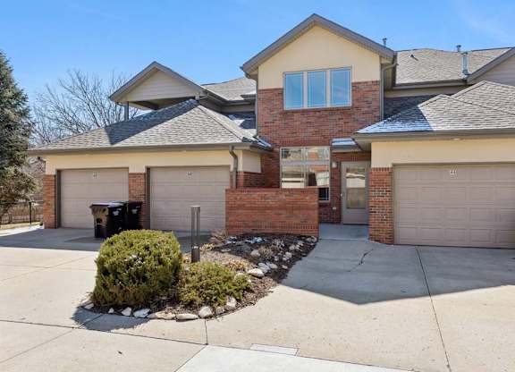 Exterior view of townhome building with private garages and shared driveway.