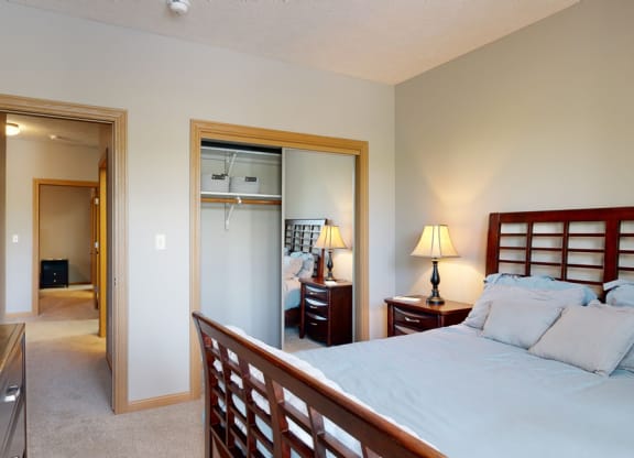 a bedroom with a bed and a mirrored closet door