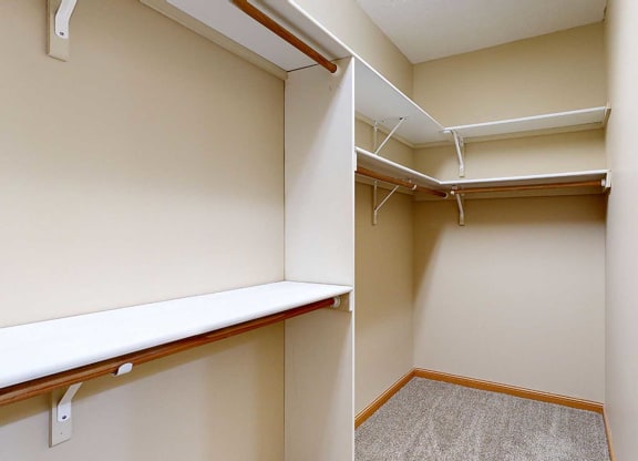 a walk in closet with built-in shelves