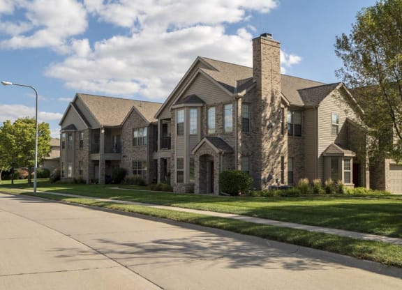 Wide neighborhood street and exterior private apartment entrances at Stone Creek Villas townhomes in west Omaha NE 68116
