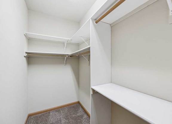 Walk-in closet with built-in shelving, hanging rods, and additional storage space.