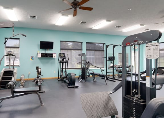 24 hour fitness center with exercise equipment and a flat screen tv