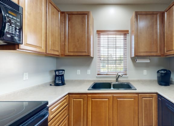 a kitchen with wooden cabinets and a window