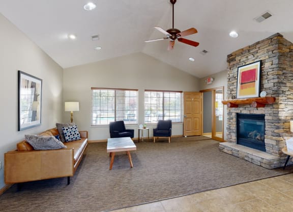 Clubhouse living room with a fireplace and a ceiling fan
