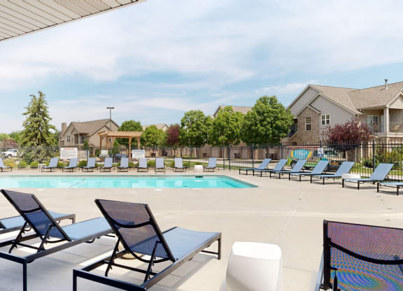 a swimming pool with chaise lounge chairs and trees in the background