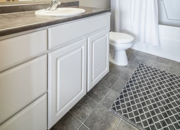 Bathroom with white cabinetry and bathtub at Stone Ridge townhomes in south Lincoln NE