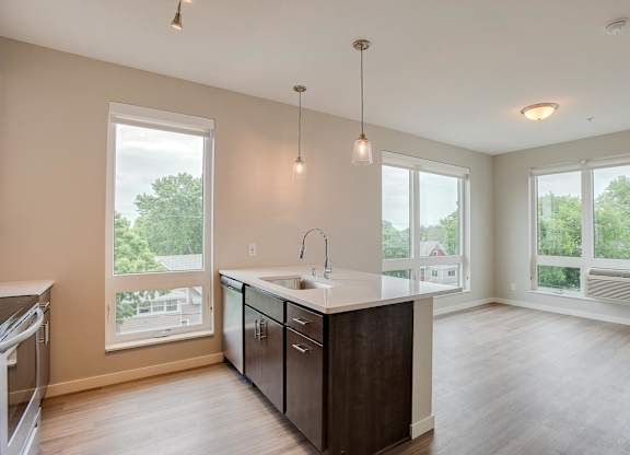 A kitchen with a large island and pendant lights.