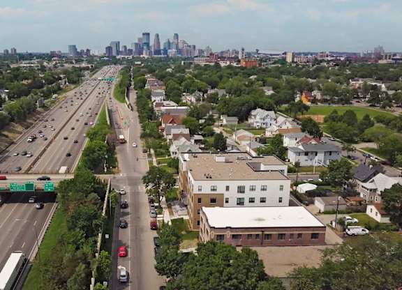 A highway with cars and buildings on the side.