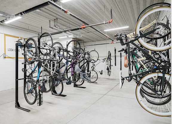 a bike locker room with multiple mounted spaces to hang bikes
