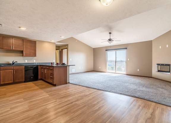 A spacious kitchen with wooden floors and a ceiling fan.