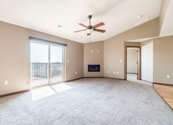 A spacious living room with a fireplace and sliding glass doors.