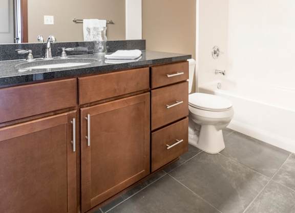Bathroom with granite countertops and tile floors at The Flats at 84 in southeast Lincoln NE 68516