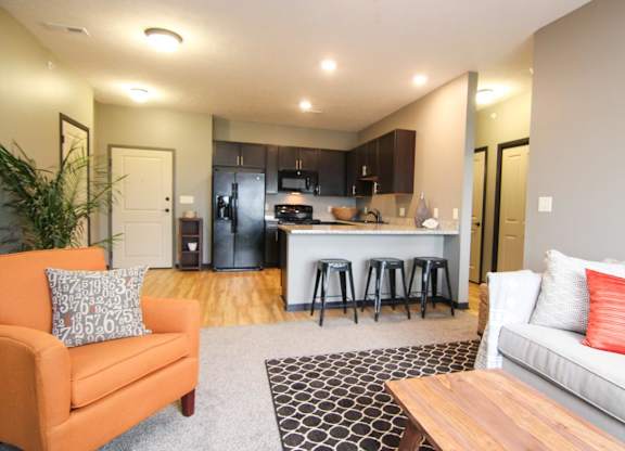 A living room with a couch, chair, and a bar area.