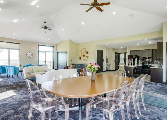a dining area with a table and chairs and a kitchen in the background