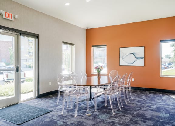 a table and chairs in front of a door in the flats at 84 clubhouse