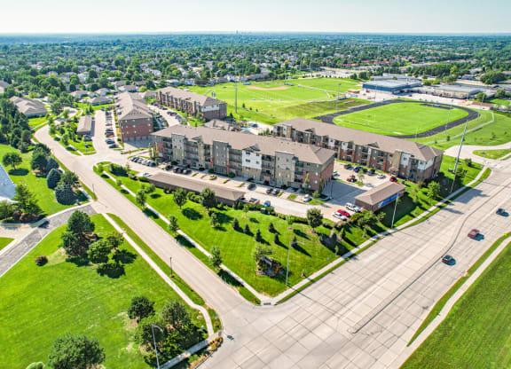 an aerial view of a large apartment complex with green fields in the background