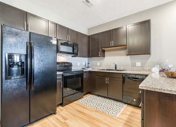 a large kitchen with stainless steel appliances and granite counter tops