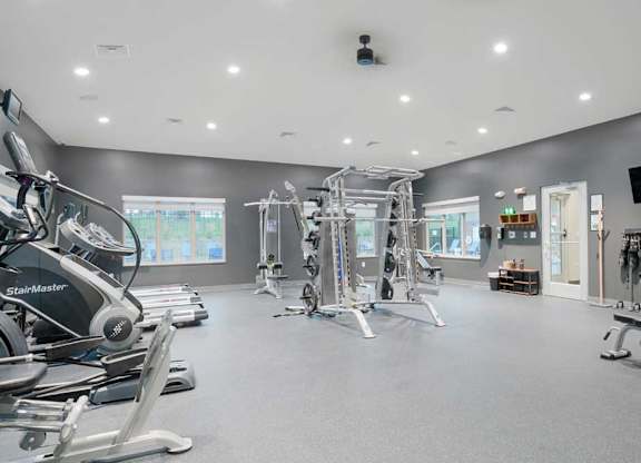 Spacious fitness center with cable machines, strength equipment, and expansive open floor space for exercise.