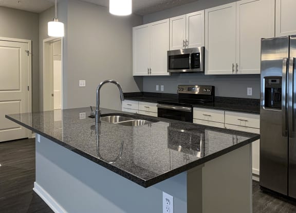 Large kitchen island with granite countertops and sink