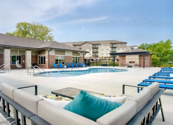Resort style pool with lounge chairs and couches outside the clubhouse at The Flats at Shadow Creek