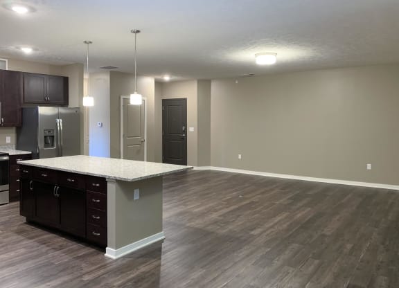 Large living and dining area with hardwood floors and a granite kitchen island
