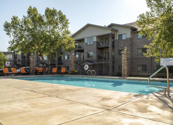 a swimming pool with lounge seating  at Grand Legacy apartments and townhomes in west Omaha NE 68130