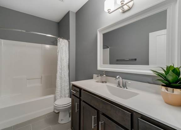 A bathroom with a white tub, sink, and toilet.