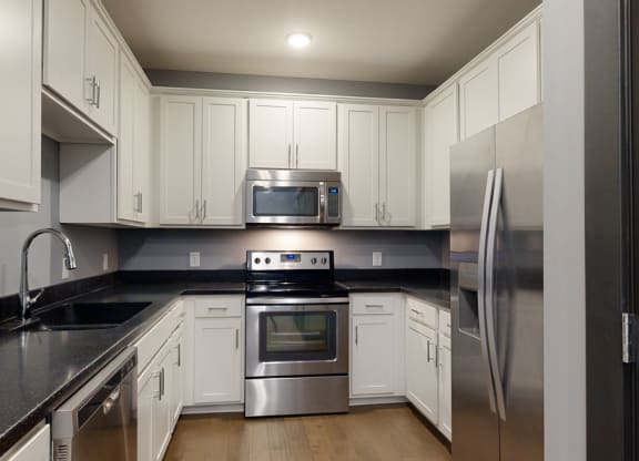 a kitchen with white cabinets and stainless steel appliances