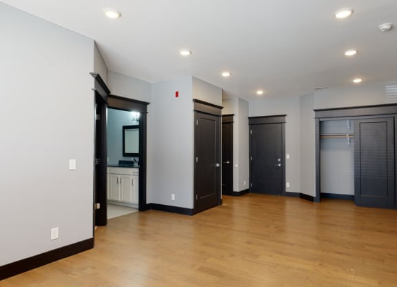 Living room with light gray walls, black trim, and wooden floors