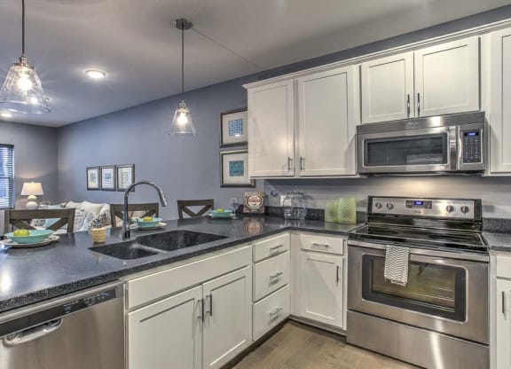 Large open floor plan kitchen with white cabinetry and stainless steel appliances