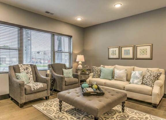 Furnished open floor plan living room with large windows for natural light at The Helen