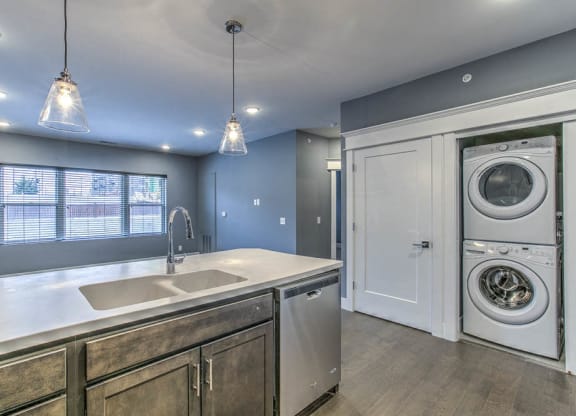 Kitchen with hanging light fixtures and washer and dryer in attached closet at The Helen