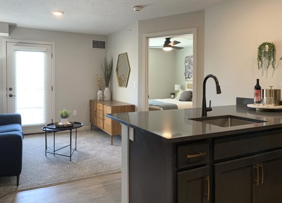 a kitchen with an island and a living room in the background