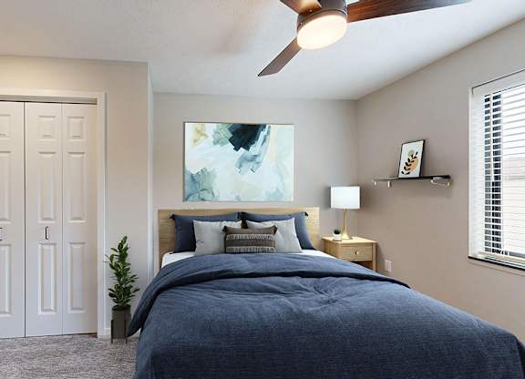 A bedroom with a bed, a ceiling fan, and a painting on the wall.