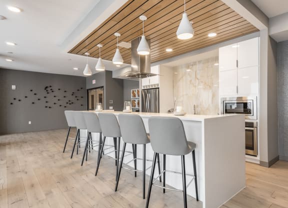 View of gourmet kitchen and bar stools in amenity space at The Preserve in Bloomington