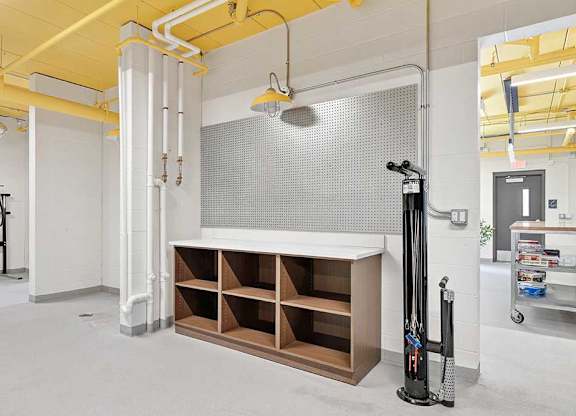 A room with a white wall and a yellow ceiling with a white pipe running along it.