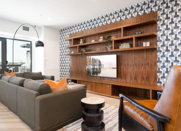 Community space television lounge with grey couch and yellow accent pillows