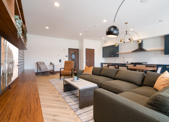 community space television lounge with grey sectional couch and yellow accent pillows.