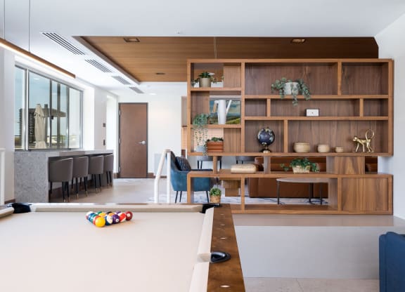 Pool table in the entertainment suite with aesthetic wooden shelf in the back