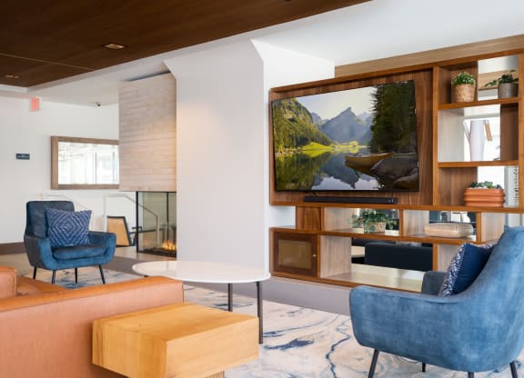 television lounge in the entertainment suite with blue chairs for seating.